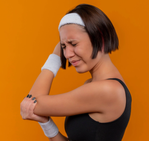 Woman experiencing tennis elbow/lateral epicondylalgia