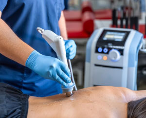 Physical therapist applying shockwave treatment
