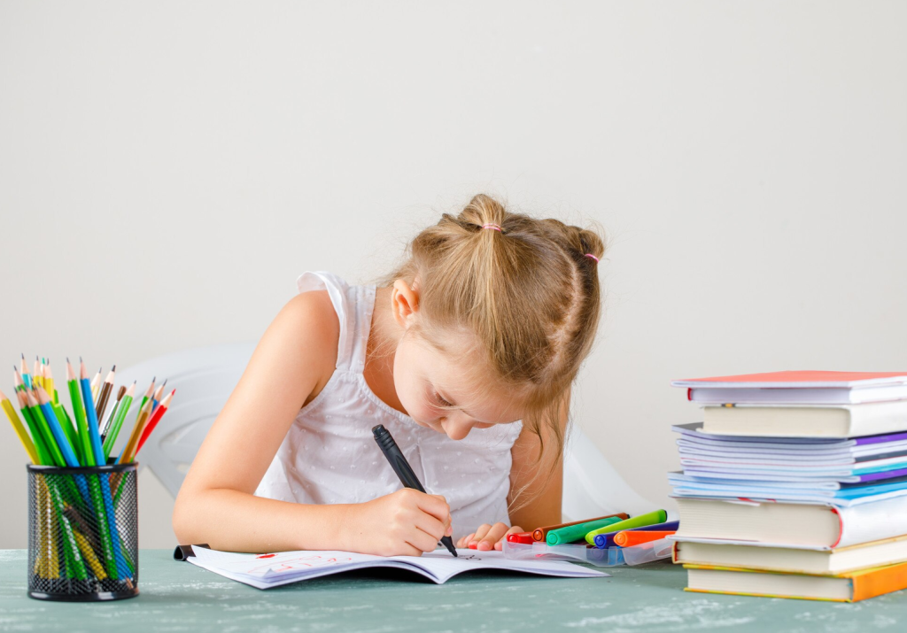 Girl doing homework with a head bent forwards position, illustrating the types of posture commonly seen and ones that can lead to pain developing
